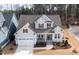 Aerial view of a light blue, two-story home with red shutters, a gray roof, front porch, and two-car garage at 1129 Sequoia Creek Ln, Cary, NC 27519
