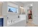 Bathroom with a large window providing natural light to the tub and closet view at 1129 Sequoia Creek Ln, Cary, NC 27519