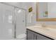 Modern bathroom featuring a glass-enclosed shower, stylish vanity with light countertops and coastal-themed decor at 1129 Sequoia Creek Ln, Cary, NC 27519