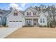 Charming two-story home featuring light blue siding, red shutters, front porch, and an attached two-car garage at 1129 Sequoia Creek Ln, Cary, NC 27519