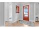 Inviting foyer featuring wood floors, a red front door, a decorative mirror and white trim at 1129 Sequoia Creek Ln, Cary, NC 27519