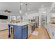 Open-concept kitchen showcasing a large island with seating, stainless steel appliances, and a walk-in pantry at 1129 Sequoia Creek Ln, Cary, NC 27519