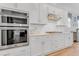 Well-equipped kitchen showcasing built-in ovens, white cabinetry, and a sleek range hood at 1129 Sequoia Creek Ln, Cary, NC 27519