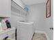 Well-lit laundry room featuring modern, front-load washer/dryer set, convenient shelving, and tasteful decor at 1129 Sequoia Creek Ln, Cary, NC 27519