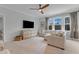 Inviting living room with plush seating, a ceiling fan, and natural light from large windows at 1129 Sequoia Creek Ln, Cary, NC 27519