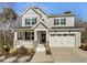 Charming two-story home with gray siding, black shutters, covered porch, and a two-car garage at 120 Breyla Way, Holly Springs, NC 27540