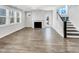 Bright living room featuring a fireplace, large windows and an adjacent staircase at 120 Breyla Way, Holly Springs, NC 27540