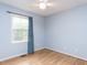 Bedroom featuring light blue walls, wood floors, and a window with natural light at 120 Galax Ln, Durham, NC 27703