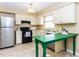 Functional kitchen with stainless steel appliances, classic white cabinets, and a bright green island at 120 Galax Ln, Durham, NC 27703