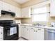 Efficient kitchen featuring white cabinets, a stainless steel dishwasher, and ample counter space at 120 Galax Ln, Durham, NC 27703