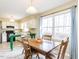 Eat-in kitchen area with wooden dining set, a large bright window, and view to adjacent functional kitchen at 120 Galax Ln, Durham, NC 27703