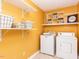 Well-organized laundry room equipped with a washer, dryer, storage shelves, and ample space at 120 Galax Ln, Durham, NC 27703