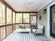 Screened porch with a ceiling fan, seating area with a table and a decorated accent wall at 120 Galax Ln, Durham, NC 27703