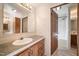 Bathroom vanity with a sink, wooden cabinets, and doorway to shower/tub at 136 Pelham St, Haw River, NC 27258