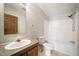 Bright bathroom features tiled floors, white tub/shower, and vanity sink at 136 Pelham St, Haw River, NC 27258