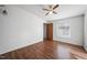 Bedroom features wood floors, ceiling fan, one window, and a wooden door at 136 Pelham St, Haw River, NC 27258