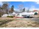 Charming single-story home with white siding, dark shutters, and a convenient carport for covered parking at 136 Pelham St, Haw River, NC 27258