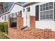 Welcoming front porch featuring brick details and a black iron railing at 136 Pelham St, Haw River, NC 27258