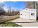 Detached garage with a concrete driveway and white wooden fence at 136 Pelham St, Haw River, NC 27258