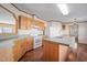 Well-lit kitchen featuring an island with wood cabinets, white appliances, and modern lighting fixtures at 136 Pelham St, Haw River, NC 27258