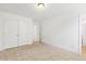 Bright bedroom with neutral carpet, double door closet, and white walls at 143 Rossell Park Cir, Garner, NC 27529