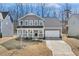Charming two-story home with a welcoming front porch and a well-manicured lawn, complete with an attached two-car garage at 143 Rossell Park Cir, Garner, NC 27529