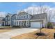 Charming two-story home with a welcoming front porch and a well-manicured lawn, complete with an attached two-car garage at 143 Rossell Park Cir, Garner, NC 27529
