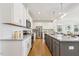 Spacious kitchen boasts white cabinets, stainless steel appliances, granite countertops, and a large island perfect for entertaining at 143 Rossell Park Cir, Garner, NC 27529