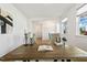 Well-lit office space with a large wooden desk, hardwood floors, and views of the neighborhood, creating an ideal work environment at 143 Rossell Park Cir, Garner, NC 27529