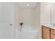 Bathroom with a white soaking tub, cabinet vanity, and a door at 146 Skyros Loop, Cary, NC 27519