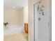 Bathroom showcasing a shower with glass door, soaking tub, and wooden cabinets at 146 Skyros Loop, Cary, NC 27519