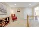 Cozy carpeted landing area with red chair, storage, and view of the stairwell at 146 Skyros Loop, Cary, NC 27519