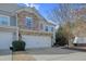 Two-story townhouse with two-car garage, stone facade, and light green siding at 146 Skyros Loop, Cary, NC 27519
