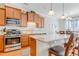 Bright kitchen with wooden cabinets, stainless steel appliances, light countertops and breakfast bar at 146 Skyros Loop, Cary, NC 27519