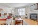 Cozy living room featuring neutral tones, a fireplace, and a seamless transition to the dining area at 146 Skyros Loop, Cary, NC 27519