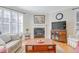 Inviting living room featuring a fireplace, hardwood floors, and large windows with plantation shutters at 146 Skyros Loop, Cary, NC 27519