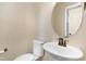 Charming half bathroom showcasing a pedestal sink with bronze fixtures and a stylish round mirror at 15 Mcdowell Pkwy, Clayton, NC 27520