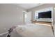 Cozy bedroom features neutral walls and a light-filled window with TV on desk at 15 Mcdowell Pkwy, Clayton, NC 27520