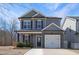 Charming two-story home featuring a manicured lawn, a two-car garage, and classic architectural details at 15 Mcdowell Pkwy, Clayton, NC 27520