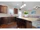 Modern kitchen with dark wood cabinetry, granite countertops, and an island with pendant lighting at 15 Mcdowell Pkwy, Clayton, NC 27520