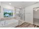 Elegant bathroom boasts a soaking tub and glass-enclosed shower with great natural light at 171 Piney Field Rd, Fuquay Varina, NC 27526