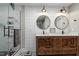 Updated bathroom with a wood vanity, dual sinks, modern lighting, patterned tile floors, and a glass-enclosed shower at 1720 Waddell Ct, Durham, NC 27703