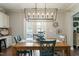 Inviting dining area with a large wood table, chairs, modern light fixture, and decorative wall art at 1720 Waddell Ct, Durham, NC 27703