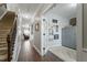 Hallway with hardwood floors leading to a staircase, living room, and opened office with French doors at 1720 Waddell Ct, Durham, NC 27703
