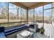 Inviting screened-in porch with outdoor seating, a deck, and views of the wooded backyard at 1720 Waddell Ct, Durham, NC 27703