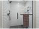 Close-up of the stylish glass-enclosed shower featuring white subway tile, a rainfall shower head, and black hardware at 1720 Waddell Ct, Durham, NC 27703