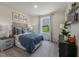 This is a bedroom with modern decor, a plush blue quilt, and scenic views from the bright window at 1745 Pie Filling Dr, Haw River, NC 27258