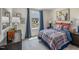 This bedroom features a plaid comforter, wood accents, and a view to the homes in the neighborhood at 1745 Pie Filling Dr, Haw River, NC 27258
