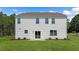 Large backyard featuring a patio, sliding glass door, plush green grass, and white vinyl siding at 186 Ethel Ln, Angier, NC 27501