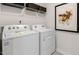 Efficient laundry room featuring a Whirlpool washer and dryer with shelving and decorative baskets at 186 Ethel Ln, Angier, NC 27501